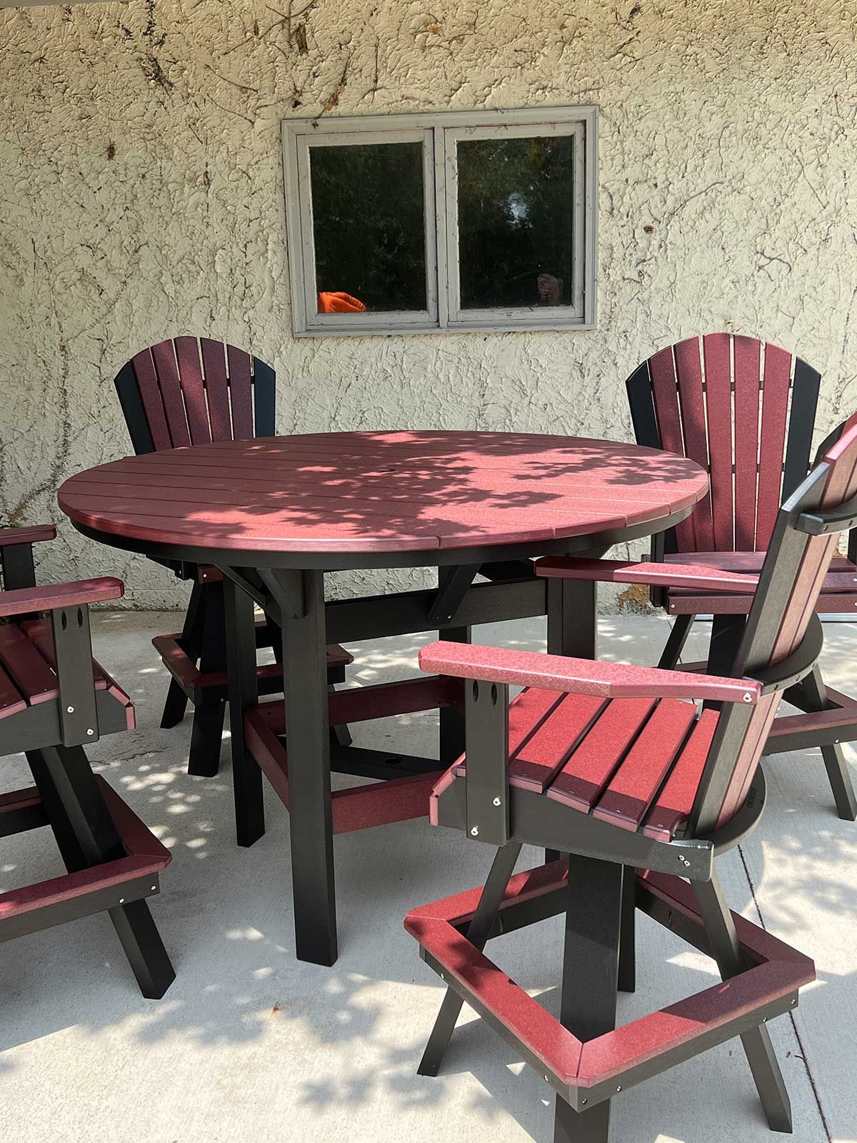A table and chairs on a patio with a window in the background