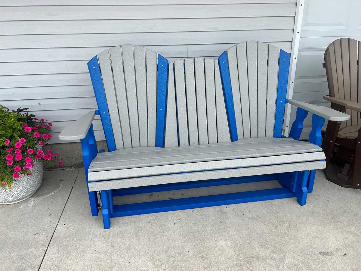 A blue and white wooden bench is sitting in front of a white wall.