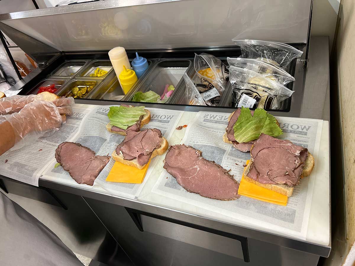 A person is preparing a sandwich in a kitchen.