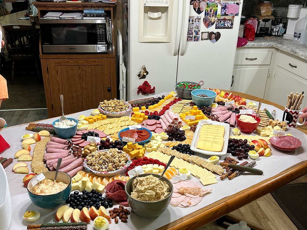 A table with a lot of food on it in a kitchen.