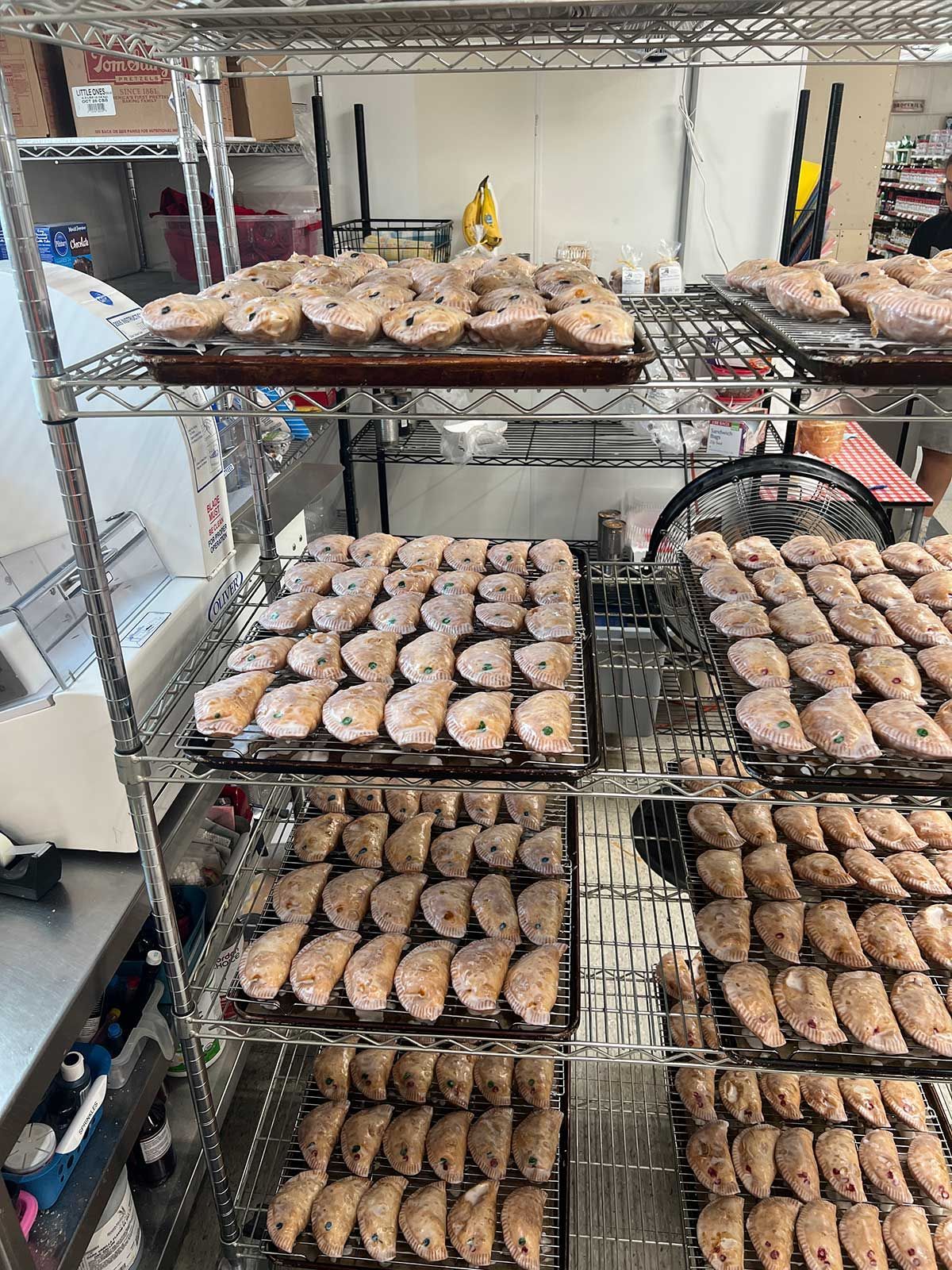 A bunch of donuts are sitting on a rack in a bakery.
