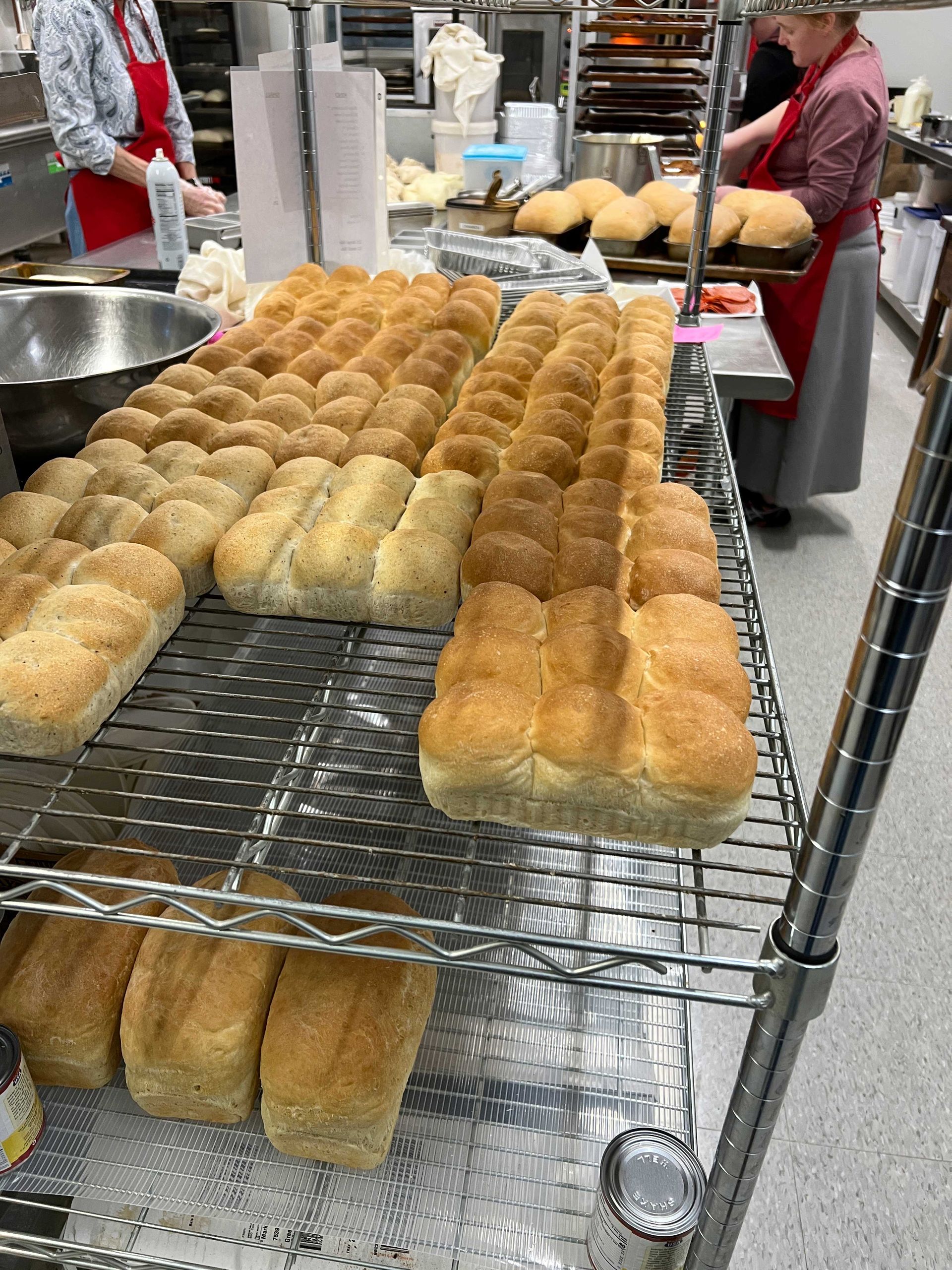 A bunch of bread is sitting on a rack in a bakery.