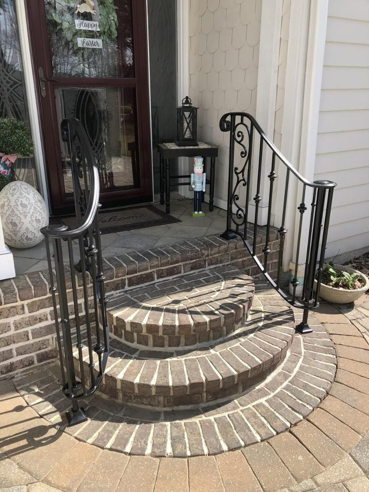 There is a wrought iron railing on the porch of a house.