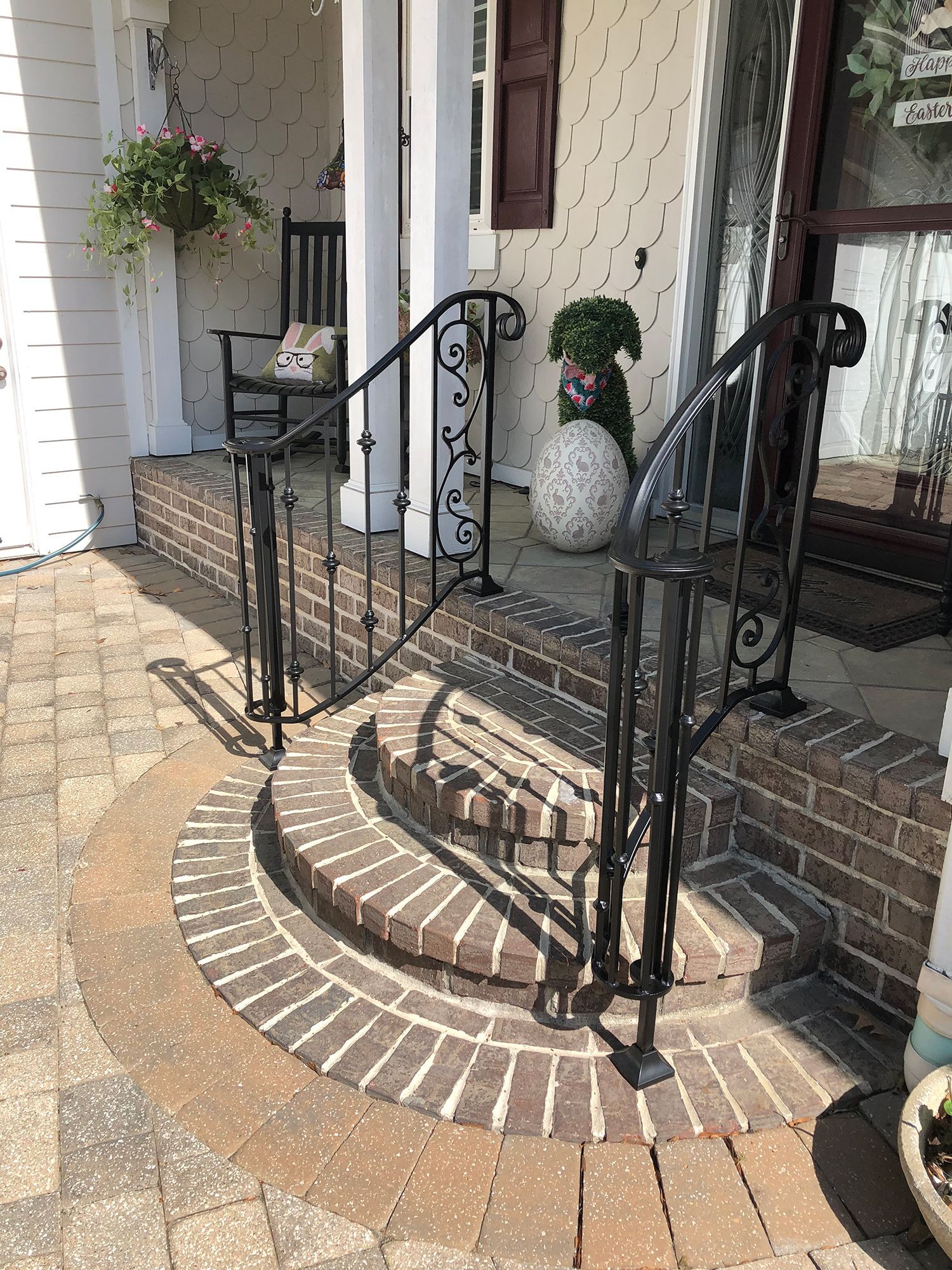 There is a wrought iron railing on the porch of a house.