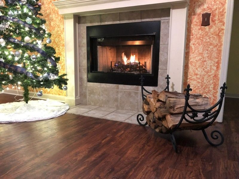 A living room with a fireplace and a christmas tree.