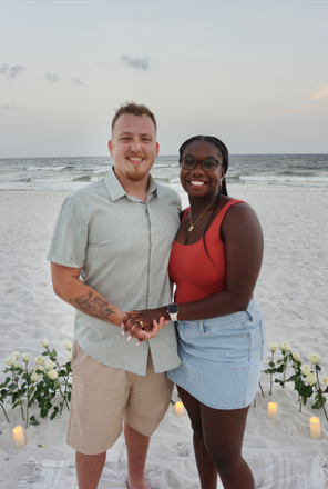 Couple on beach, holding hands.