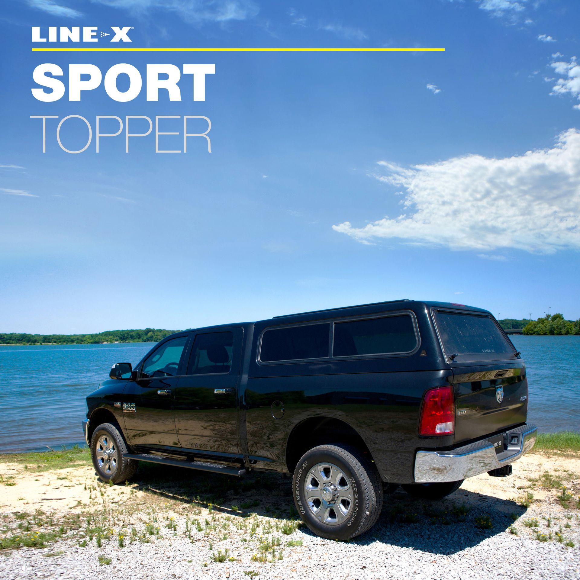 Black pickup truck with LINE-X Sport Topper parked near a lake on a sunny day.