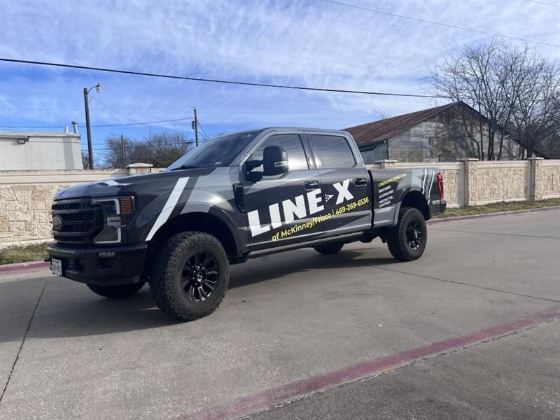 A line x truck is parked on the side of the road.