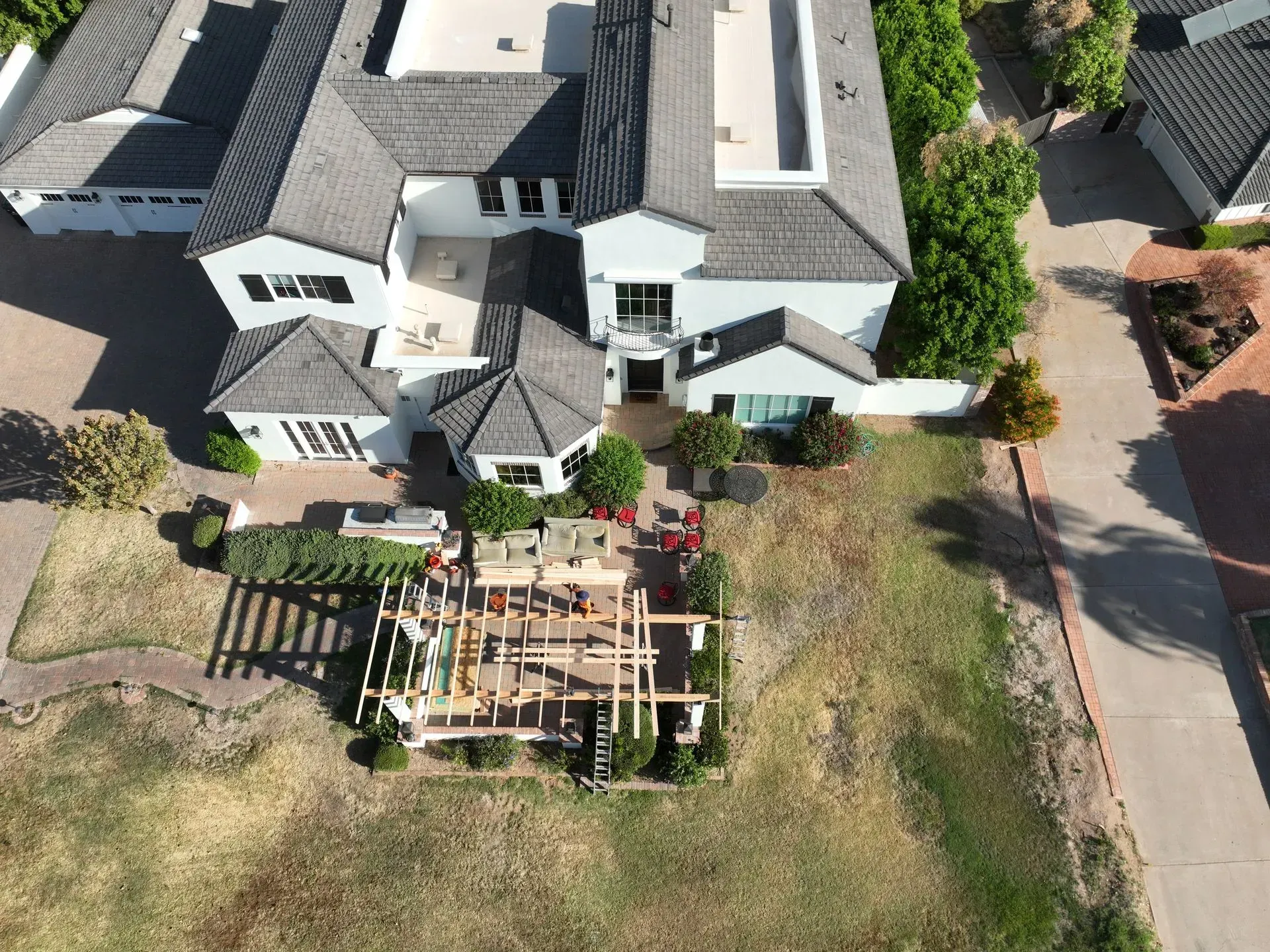 Aerial view of a house with a backyard construction site and wooden framing in the lawn