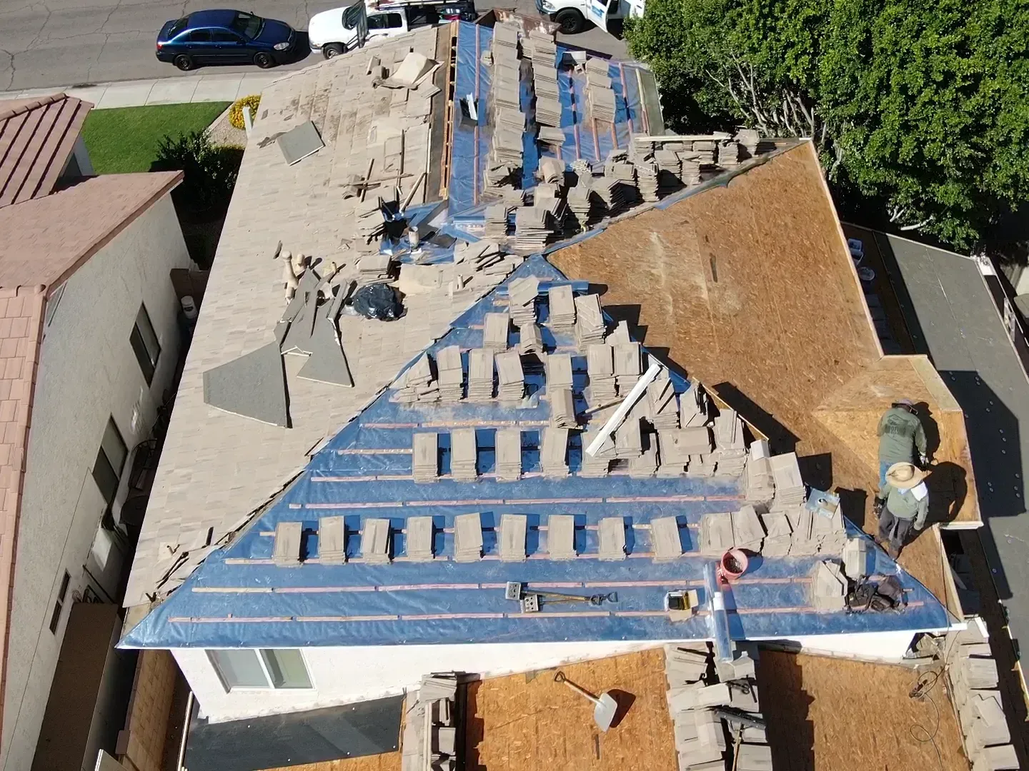 Collapsed roof on a house, with blue tarp and exposed debris after storm damage.