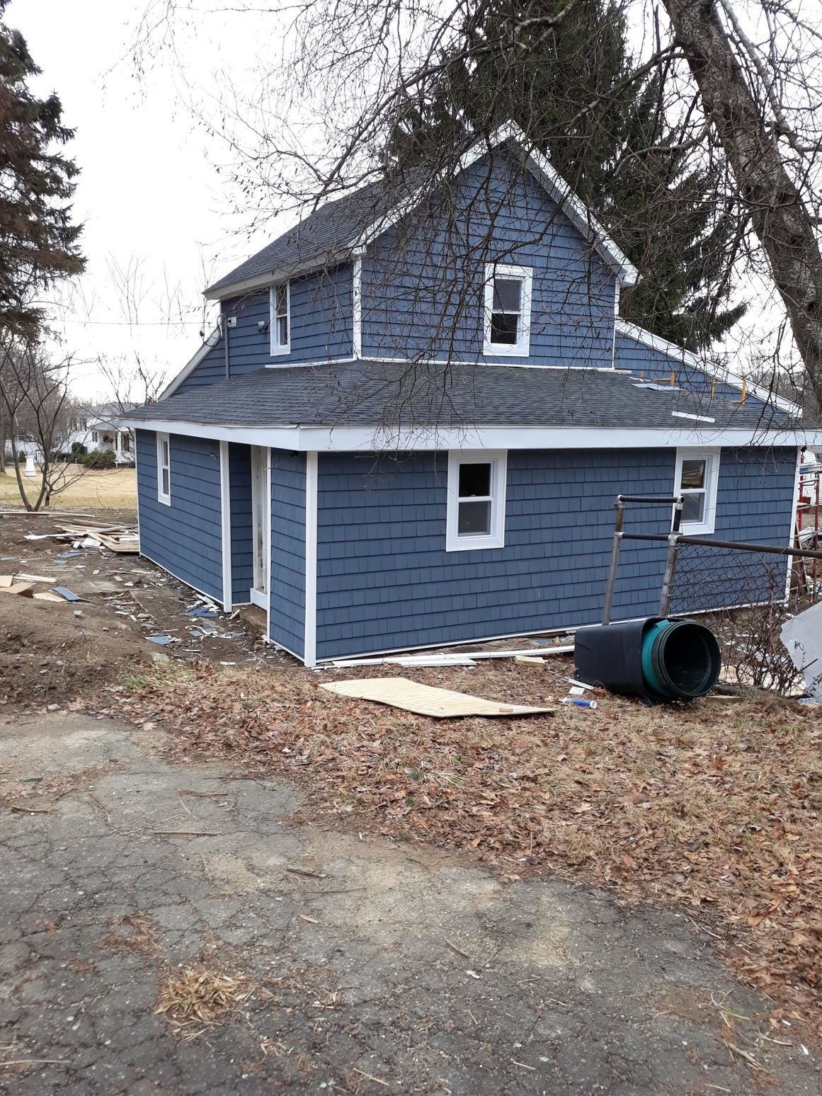 A blue house with white trim is being remodeled.