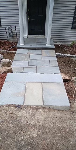 A stone walkway leading to the front door of a house.