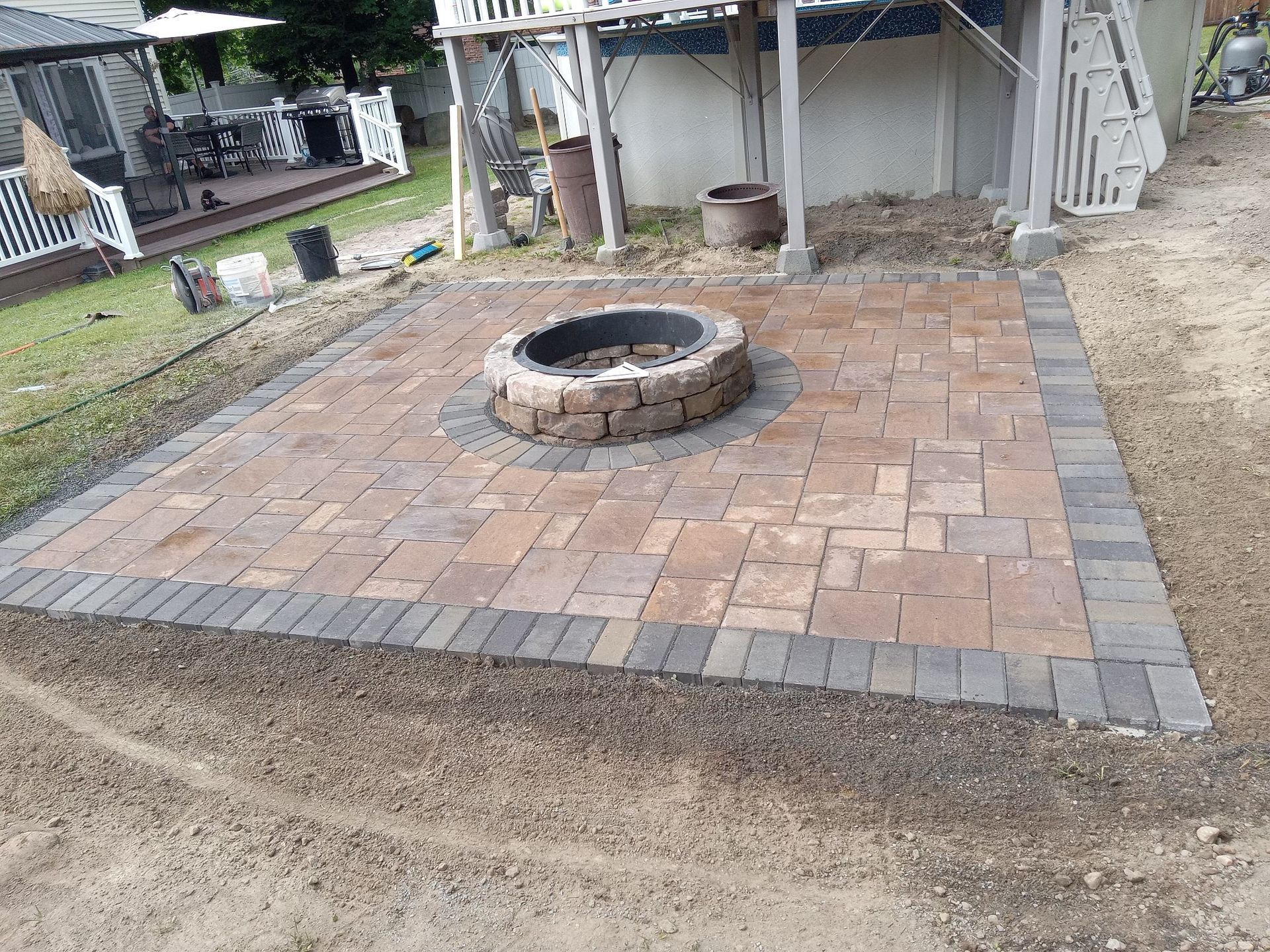 A fire pit is sitting on top of a brick patio.