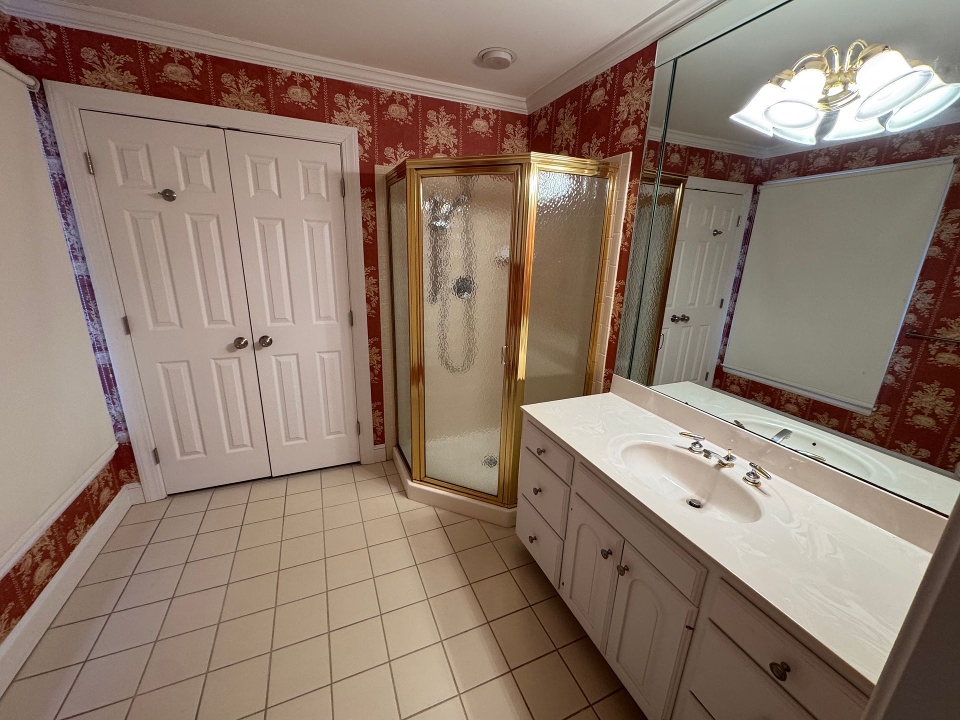 A bathroom with a sink , mirror and shower stall