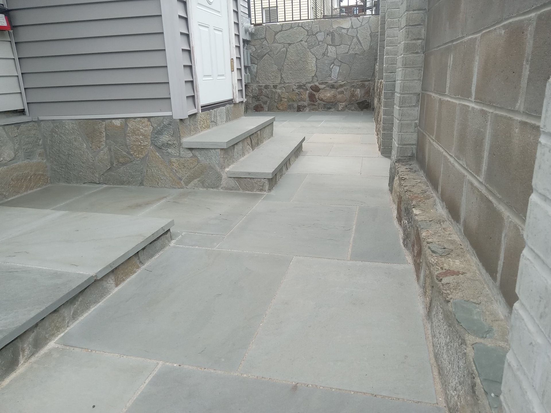 A stone walkway with stairs leading up to a house.