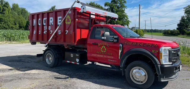 A red dump truck is parked on the side of the road