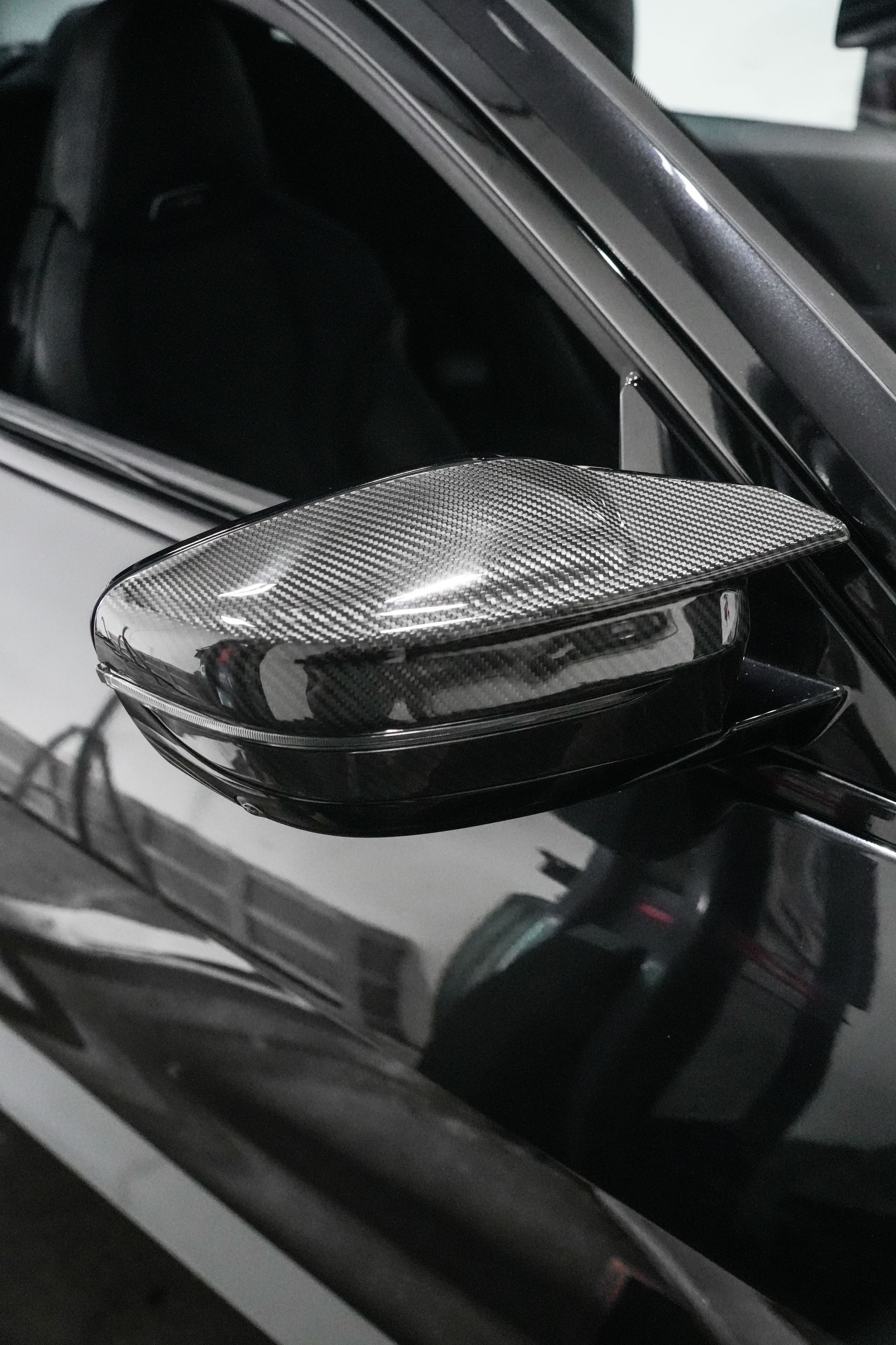 Carbon-fiber side mirror on a black car door