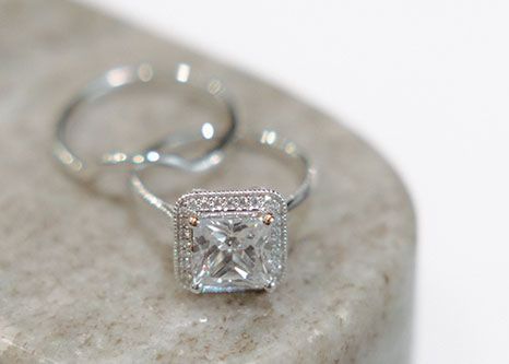 A close-up of a diamond ring and a wedding ring on a rock