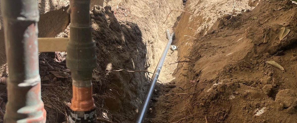 Pipes and a trench in the ground.