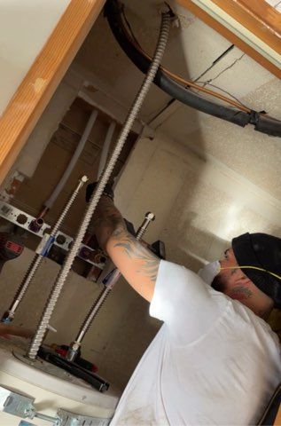 Person installing plumbing pipes inside a wall cavity.