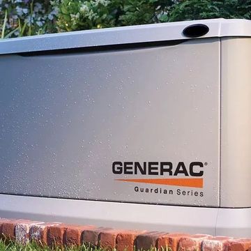A generac generator is sitting on top of a brick planter.