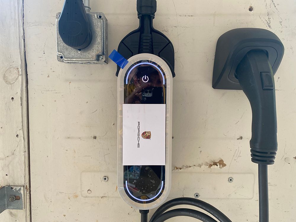 A porsche charging station is attached to a wall