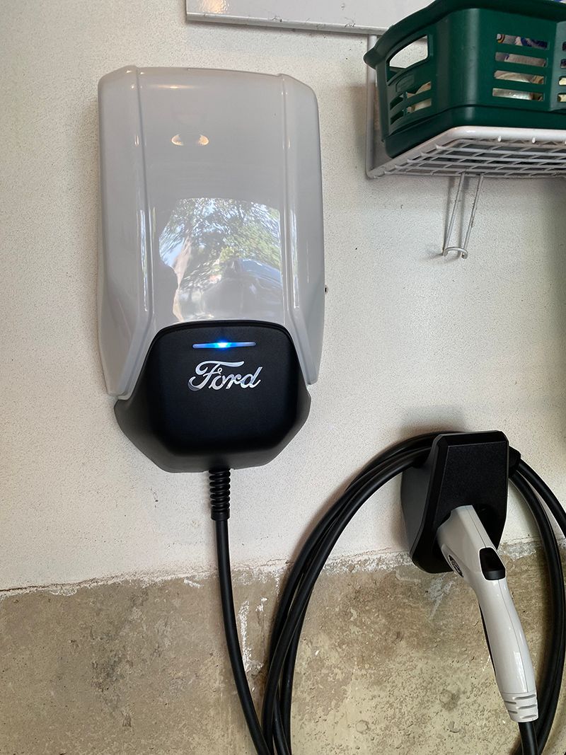 A ford electric car charger is plugged into a wall