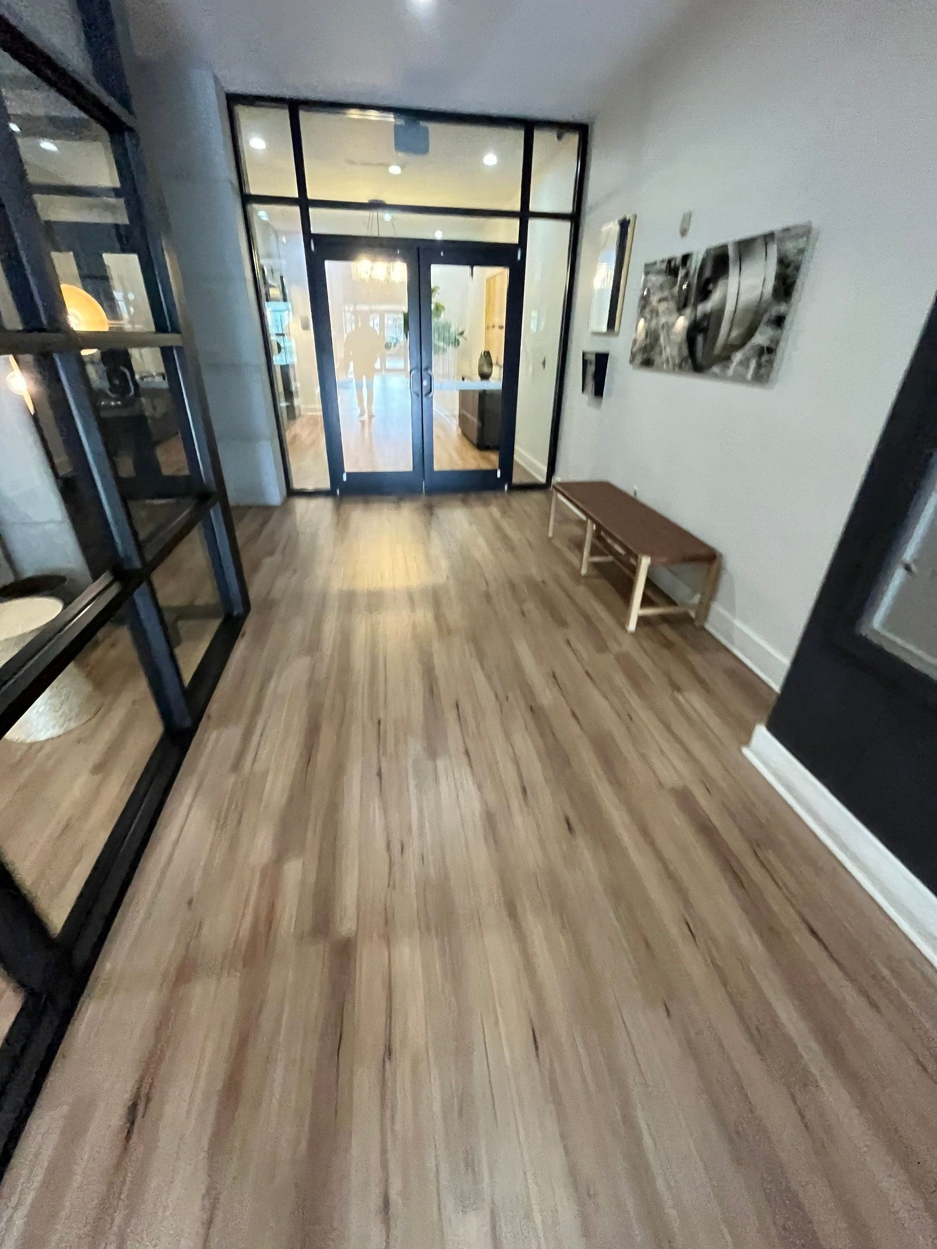 a hallway with wooden floors and a bench in the middle