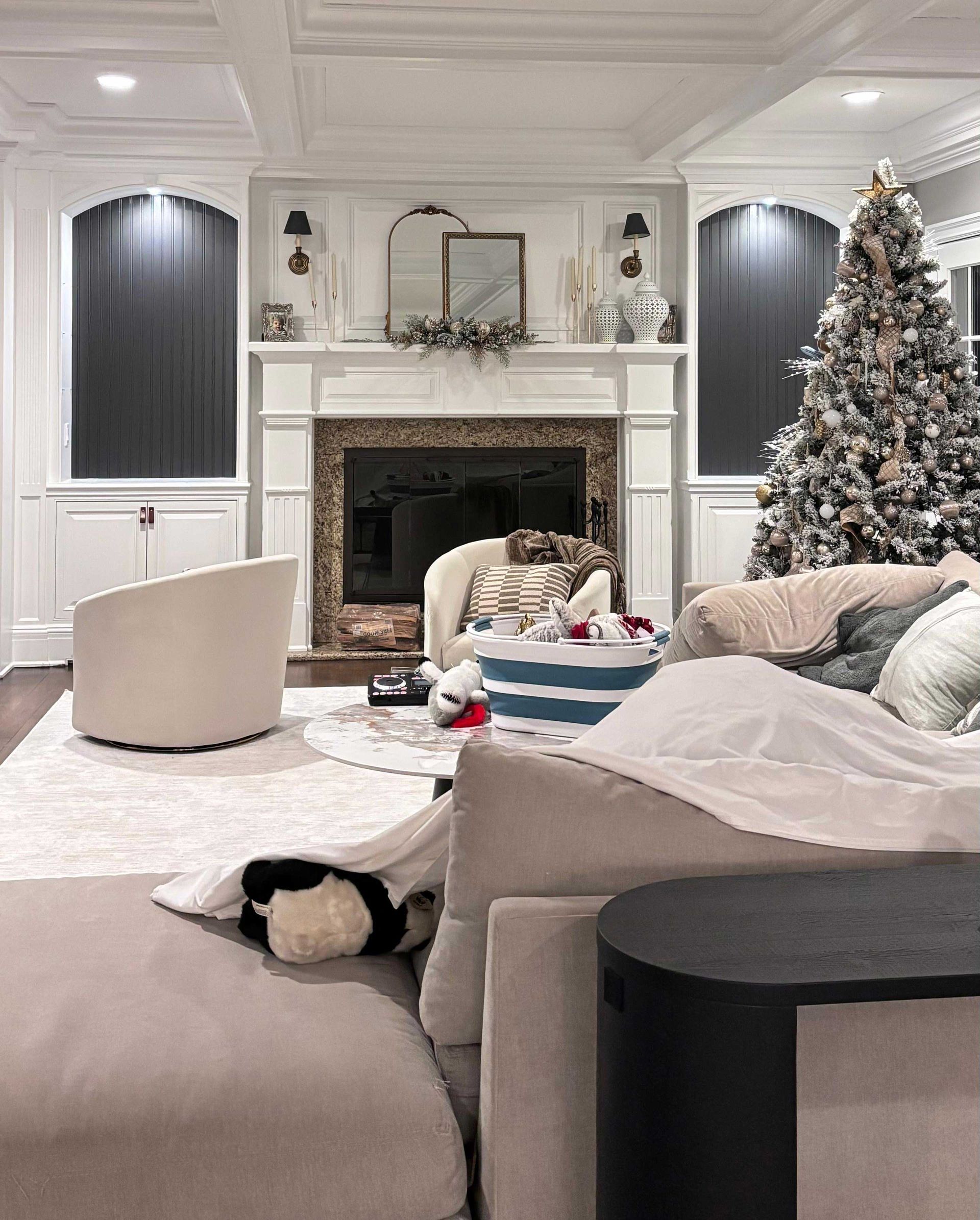 Living room with fireplace, Christmas tree, and neutral-toned furniture.