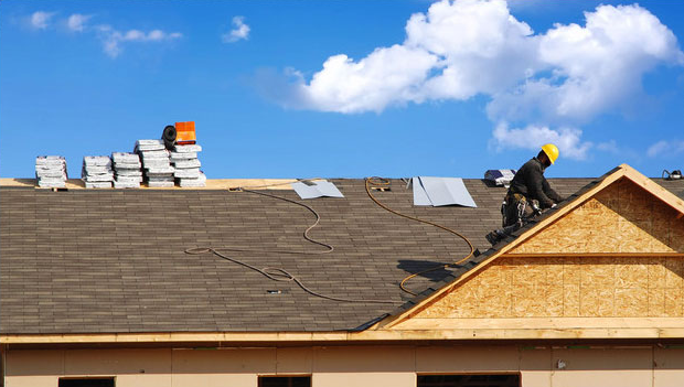 man installing new shingles