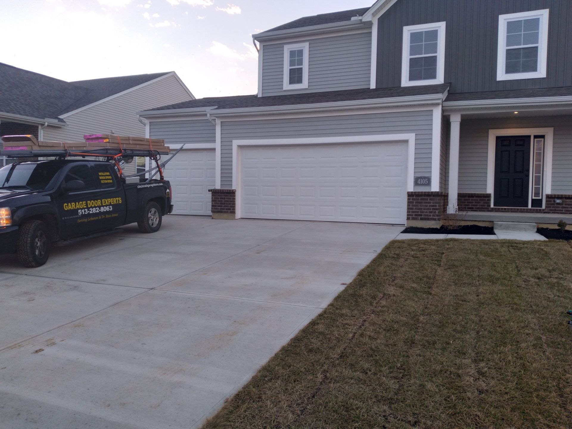 Suburban house with two-car garage and a contractor van parked in the driveway