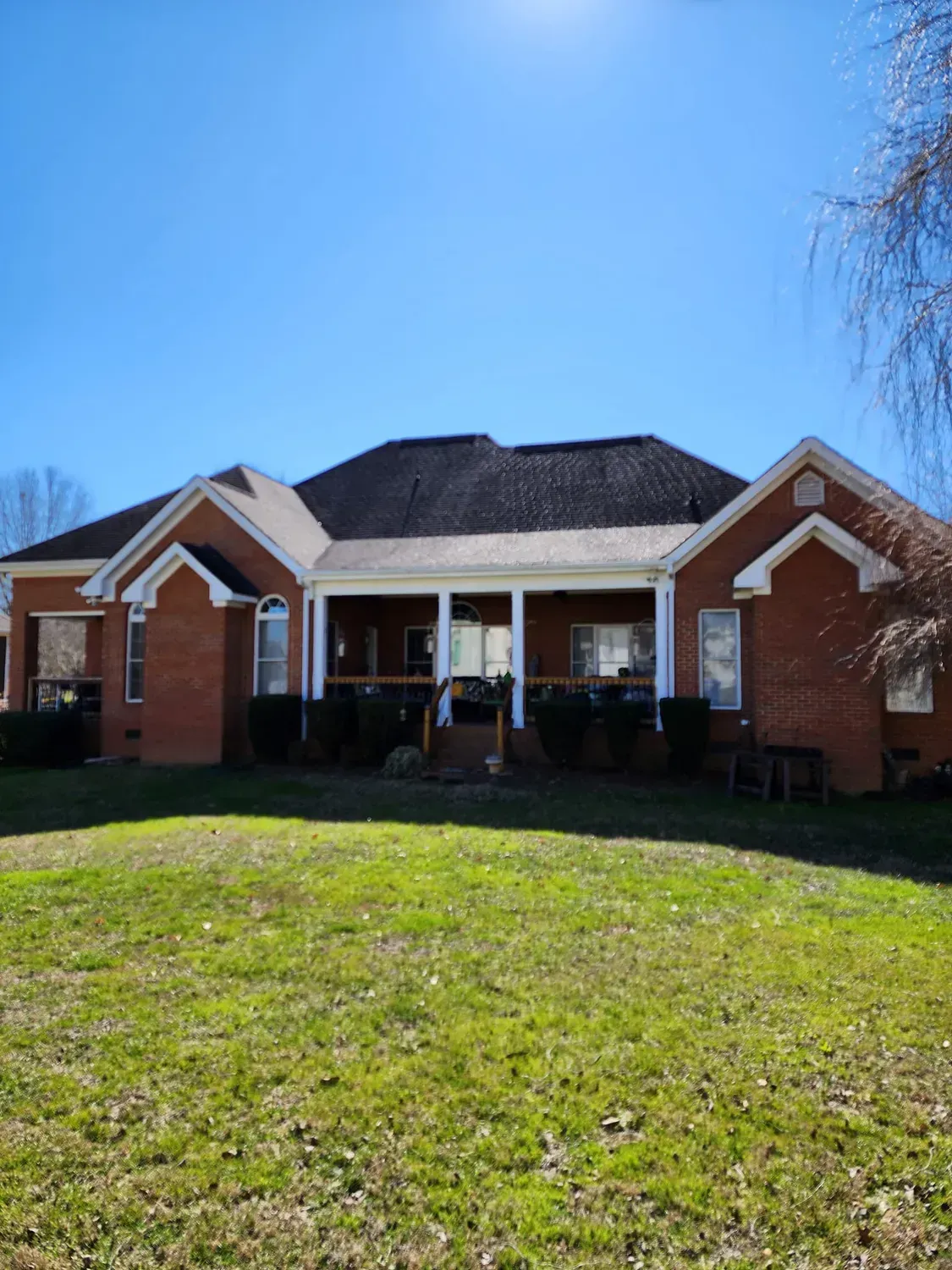 A large brick house with a large lawn in front of it