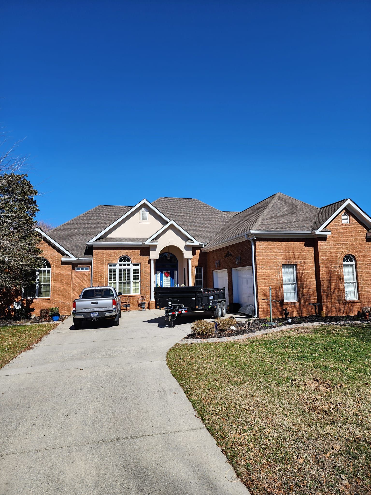 A large brick house with a truck parked in front of it.