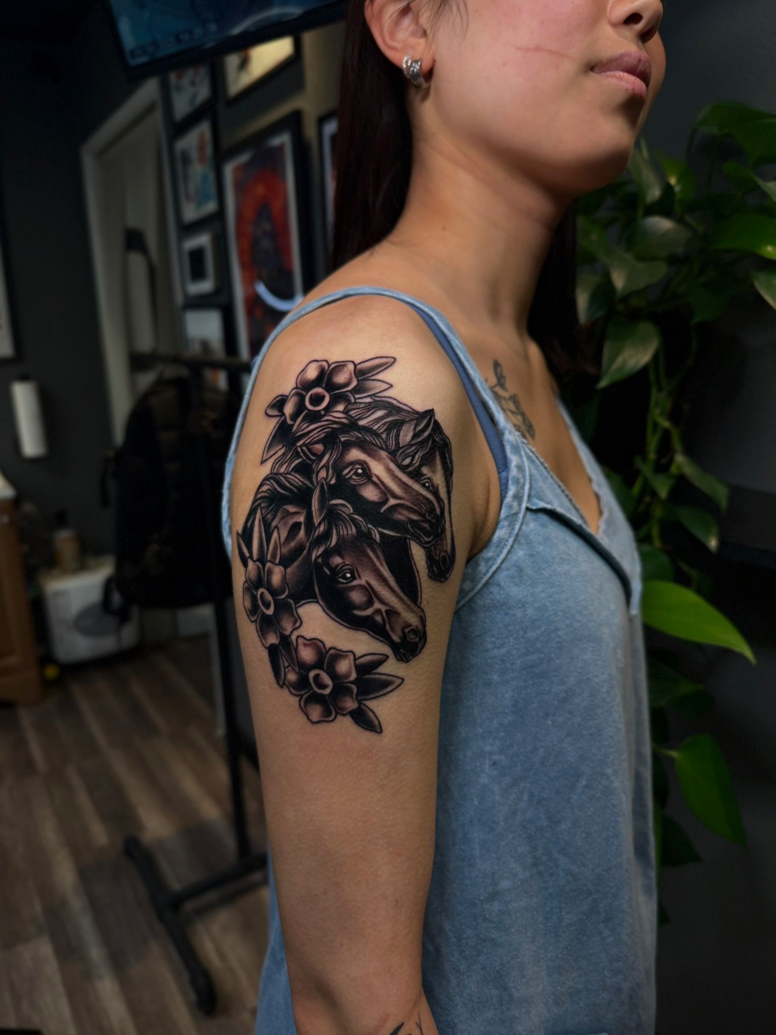 Woman with a black and gray snake tattoo on her upper arm, wearing a blue tank top.