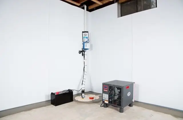 Interior room with a tall white device on a stand and a gray machine on the floor near a wall.