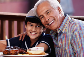 Grandfather and grandson eating happily