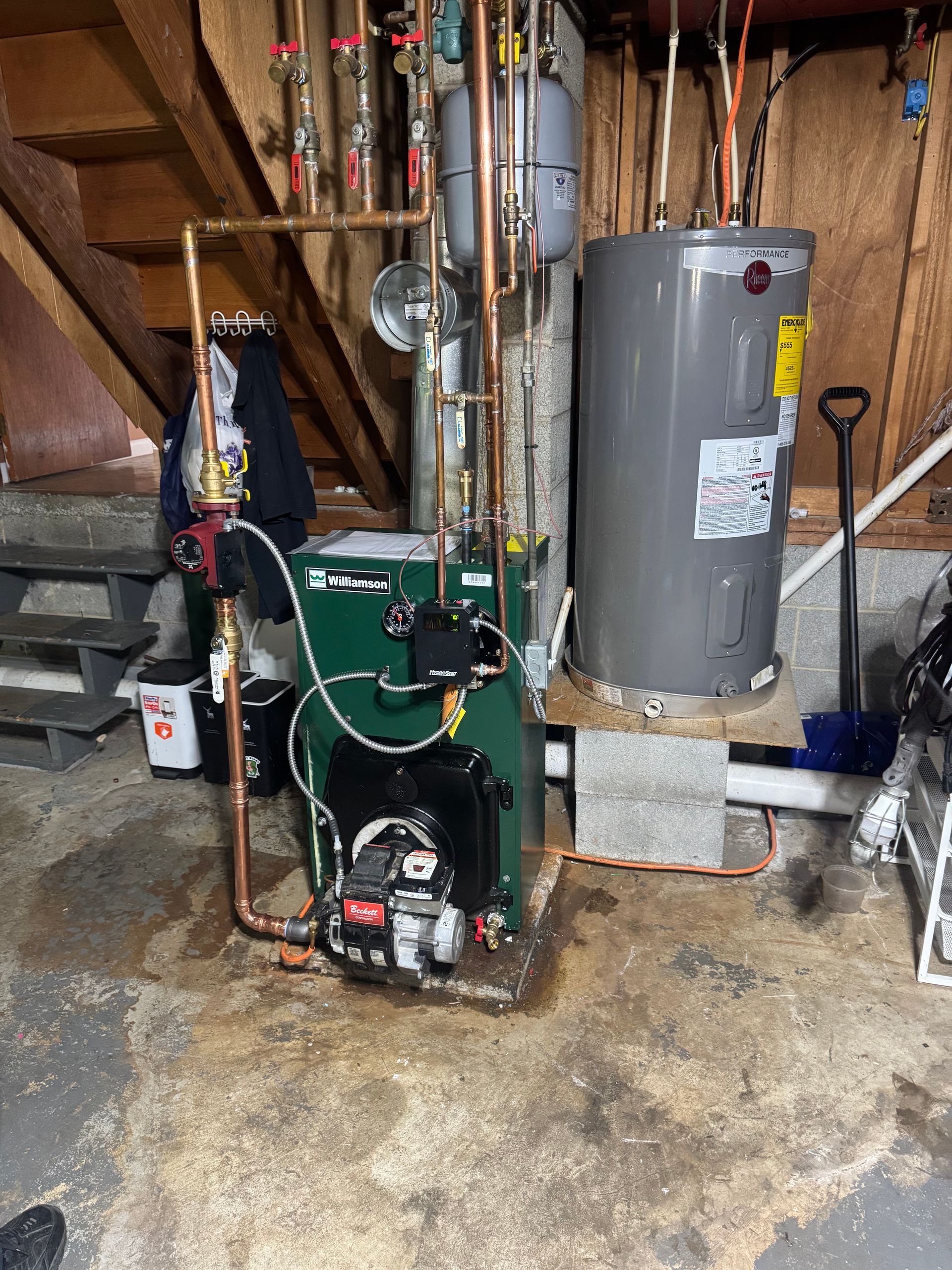 Oil burner, water heater, and copper pipes in basement setting.