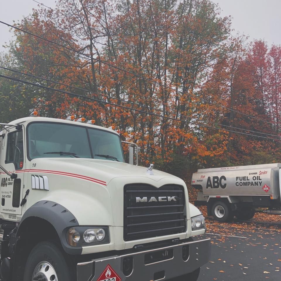 White ABC Fuel Oil Company Mack truck with trailer, in autumn setting.