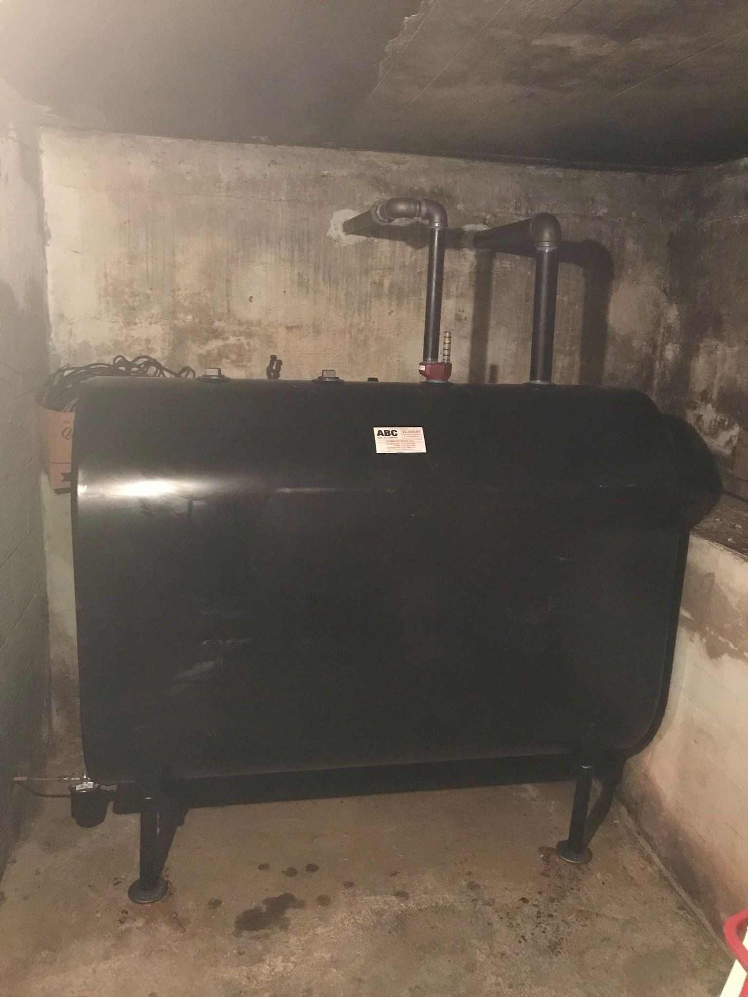 Black oil tank in a concrete basement.