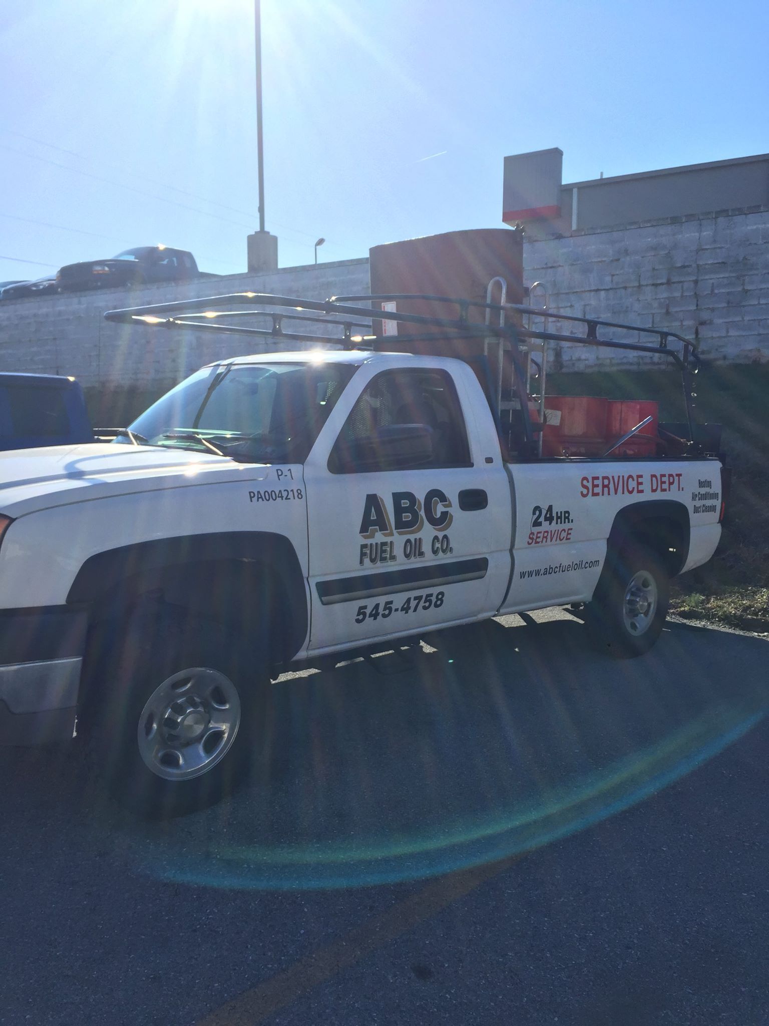 White ABC Fuel Oil truck parked outdoors on a sunny day.