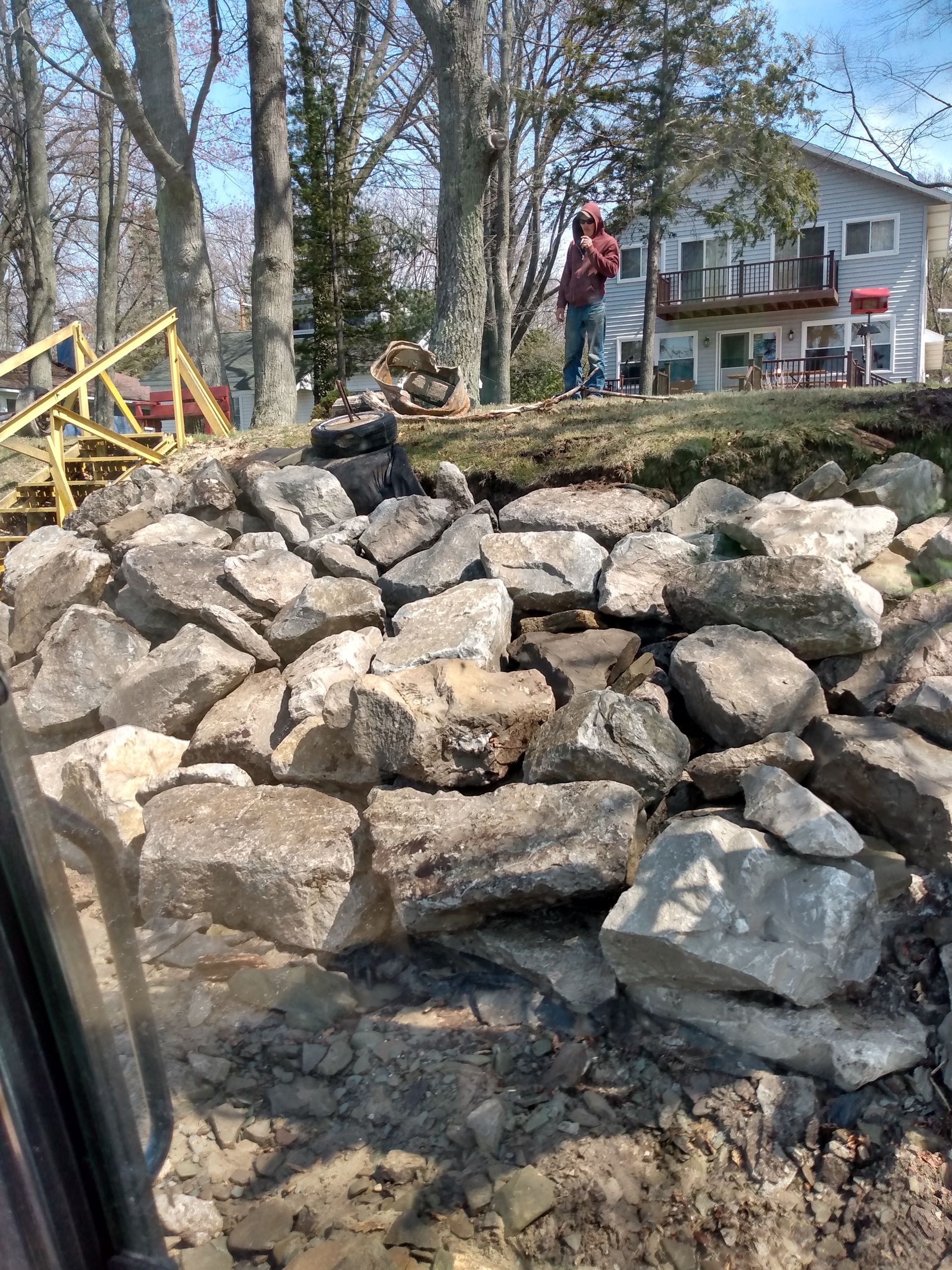 a pile of rocks is sitting in front of a house 