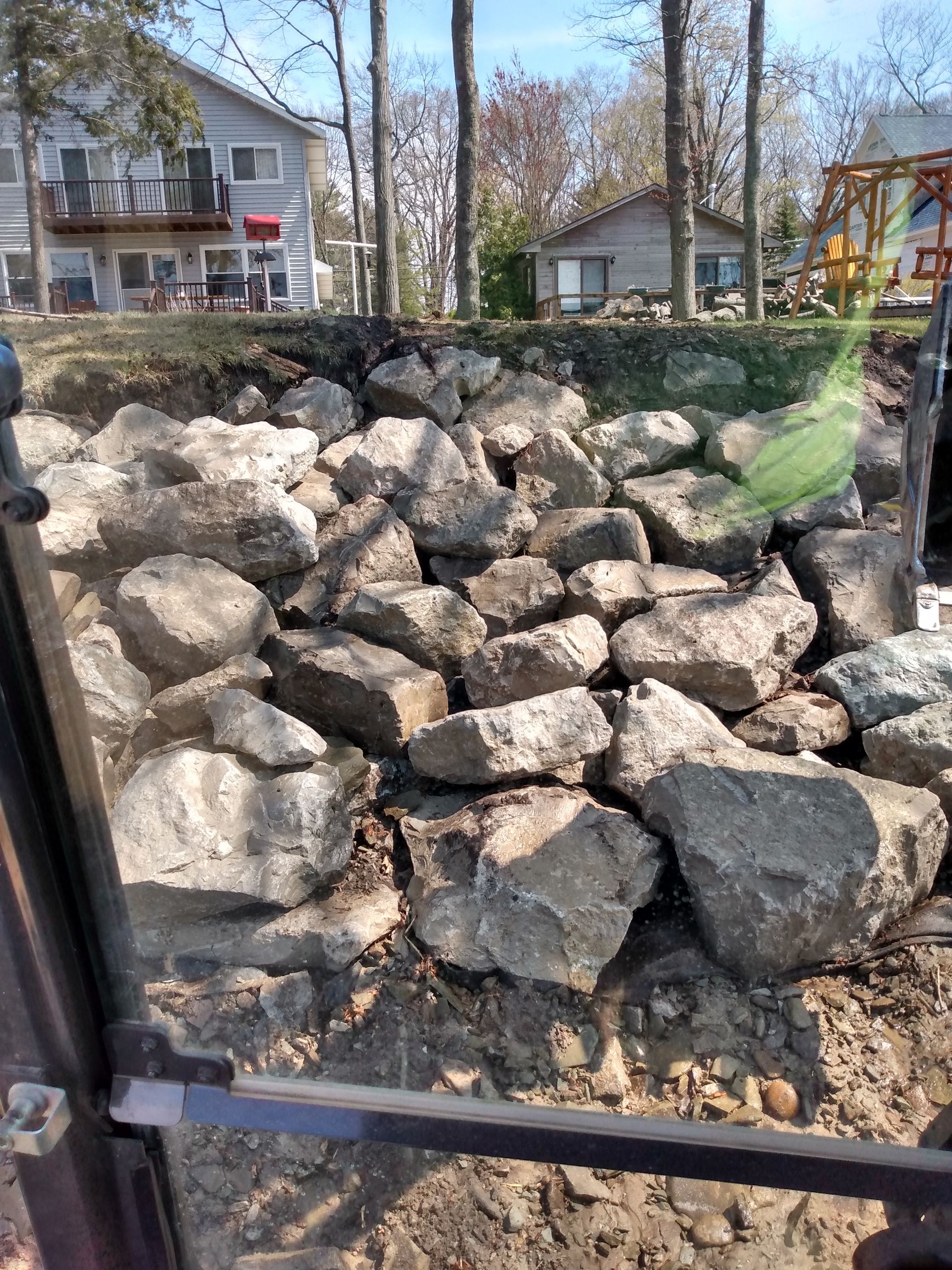 a pile of rocks is sitting in the dirt in front of a house 