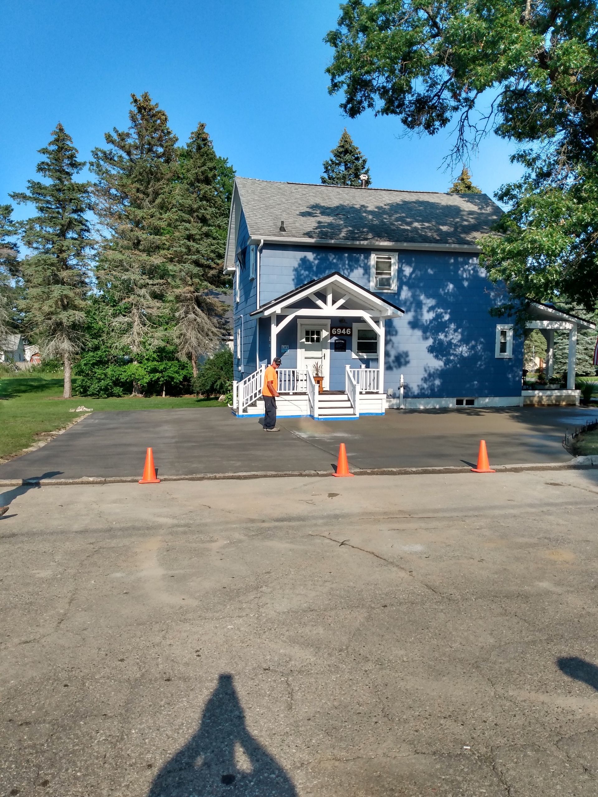 a blue house with orange cones in front of it