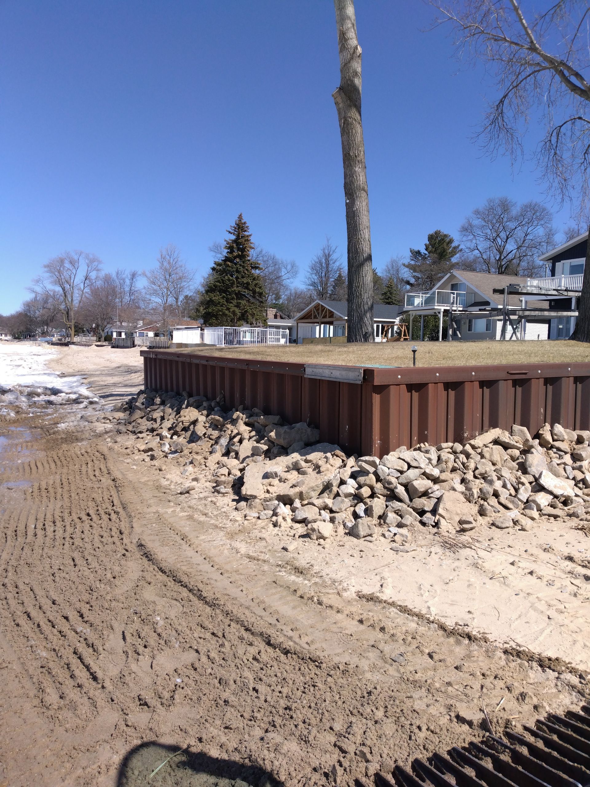 a large pile of rocks is sitting on the side of a dirt road 