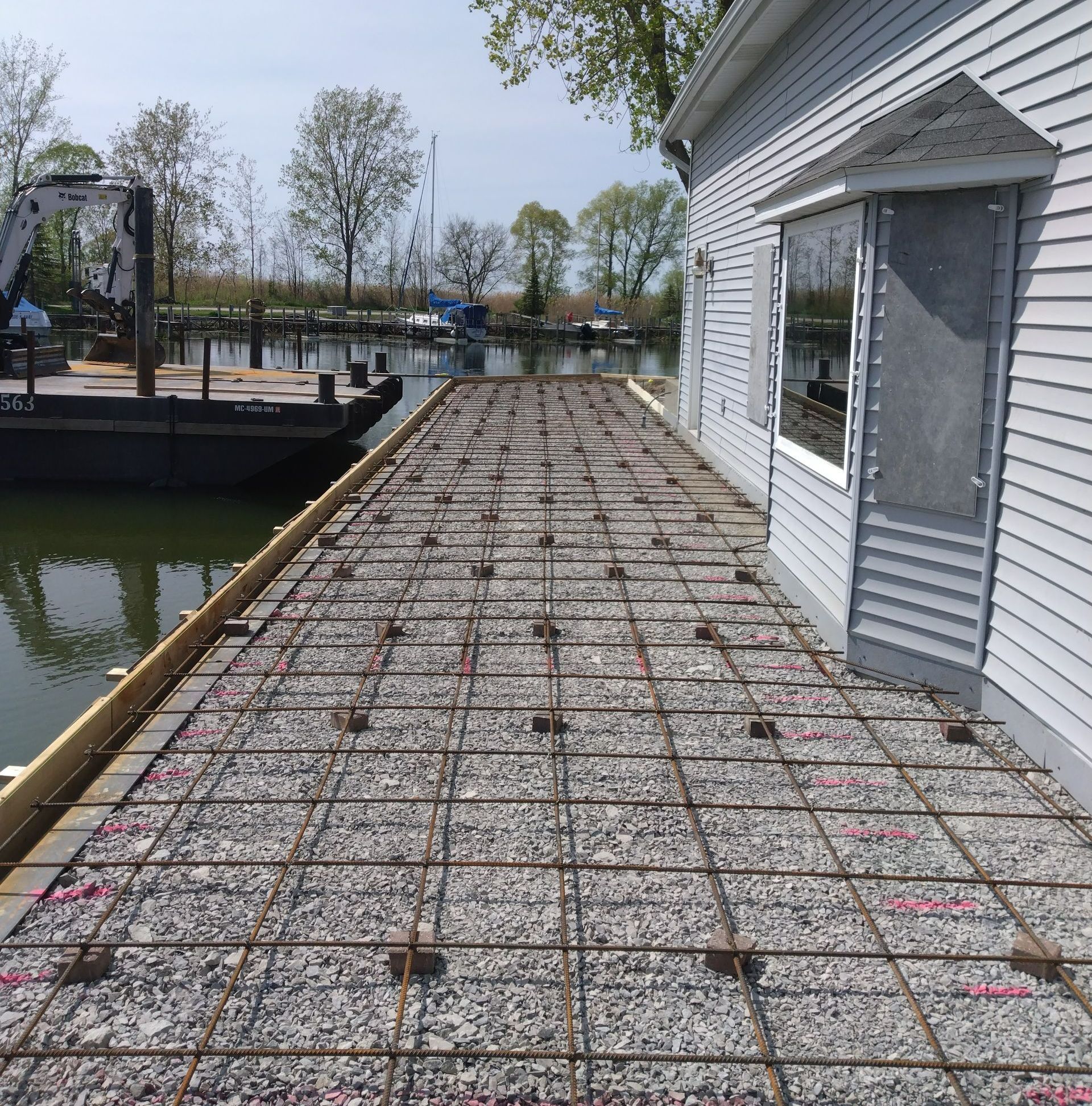 a dock is being built next to a house with a boat in the background