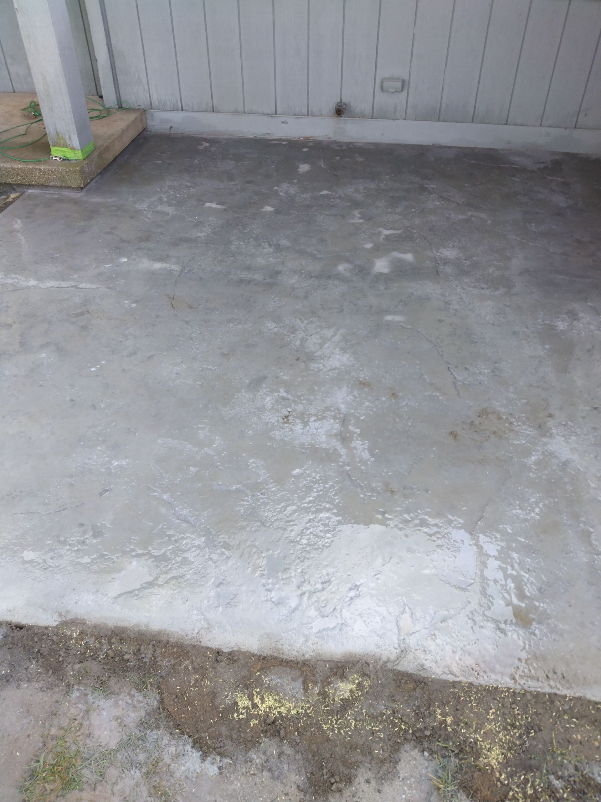 a concrete floor with a white fence in the background 