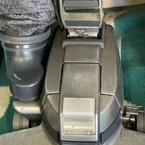 A vacuum cleaner is sitting on top of a green rug