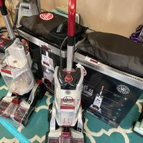 A vacuum cleaner is sitting on top of a rug next to a box