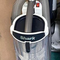 A shark vacuum cleaner is sitting on top of a table