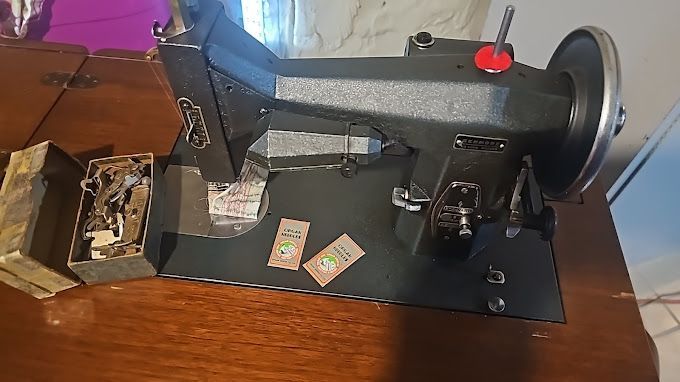 A sewing machine is sitting on top of a wooden table
